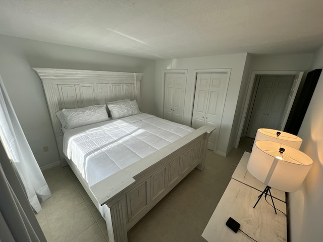 4236 Deste Ct Unit 208, Lake Worth, FL 33467 - bedroom featuring two closets, light tile patterned floors, and baseboards