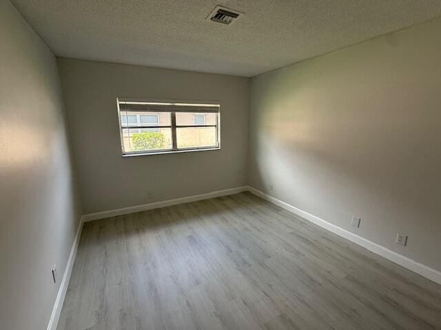 1906 Palmland Dr Unit D, Boynton Beach, FL 33436 - empty room with wood finished floors, a textured ceiling, and baseboards