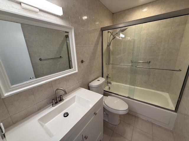 1906 Palmland Dr Unit D, Boynton Beach, FL 33436 - bathroom featuring tile walls, toilet, enclosed tub / shower combo, vanity, and tile patterned floors