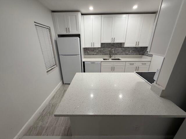 1906 Palmland Dr Unit D, Boynton Beach, FL 33436 - kitchen with white appliances, a sink, baseboards, white cabinetry, and recessed lighting