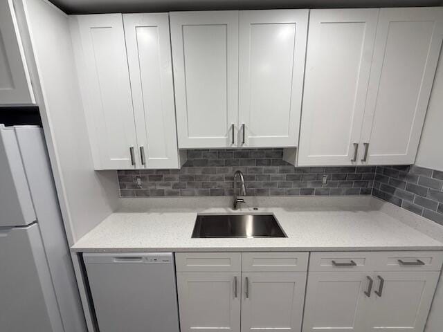 1906 Palmland Dr Unit D, Boynton Beach, FL 33436 - kitchen featuring dishwasher, a sink, freestanding refrigerator, and white cabinetry