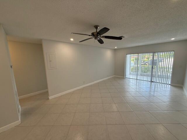 1906 Palmland Dr Unit D, Boynton Beach, FL 33436 - empty room with a ceiling fan, baseboards, a textured ceiling, recessed lighting, and light tile patterned floors