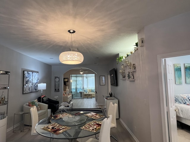 9875 Crescent View Dr S, Boynton Beach, FL 33437 - dining space featuring arched walkways, baseboards, and wood finished floors