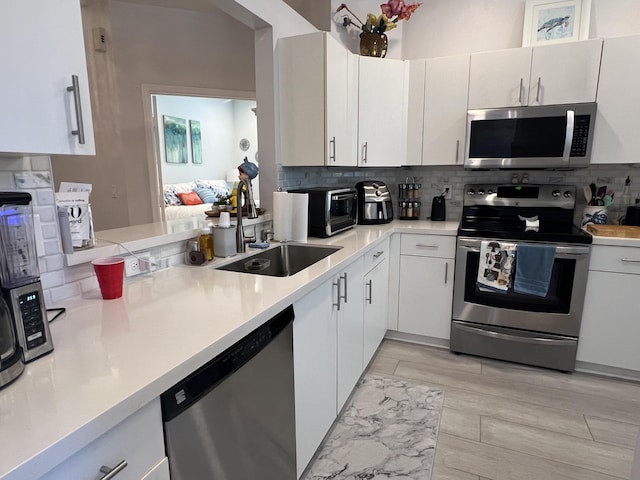 9875 Crescent View Dr S, Boynton Beach, FL 33437 - kitchen featuring appliances with stainless steel finishes, tasteful backsplash, a sink, and light countertops