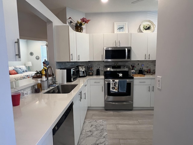 9875 Crescent View Dr S, Boynton Beach, FL 33437 - kitchen featuring appliances with stainless steel finishes, a sink, decorative backsplash, and light countertops