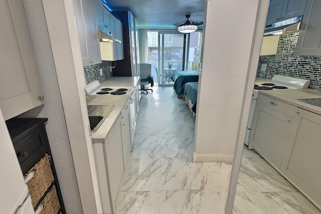 19201 Collins Ave Unit 337, Sunny Isles Beach, FL 33160 - kitchen with range, under cabinet range hood, decorative backsplash, light marble finish flooring, and light countertops