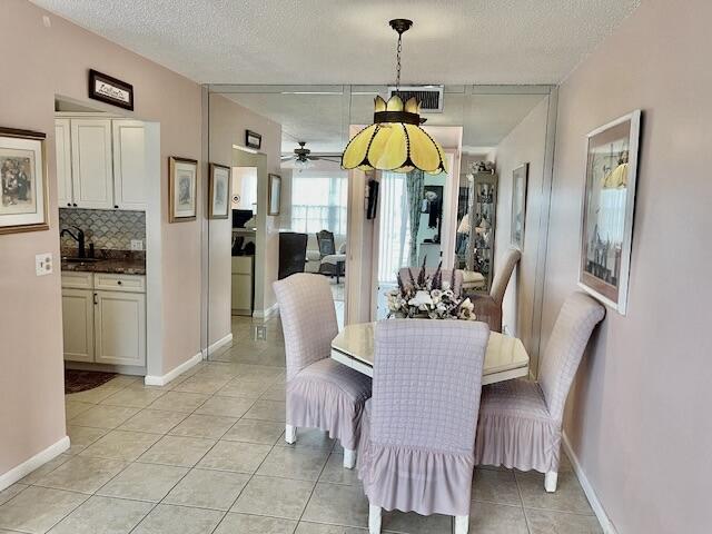 577 Mansfield N N Unit 577, Boca Raton, FL 33434 - dining room with light tile patterned flooring, a textured ceiling, baseboards, and a ceiling fan