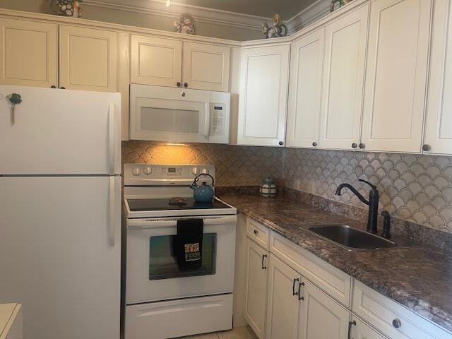 577 Mansfield N N Unit 577, Boca Raton, FL 33434 - kitchen featuring white appliances, decorative backsplash, a sink, dark stone countertops, and white cabinetry