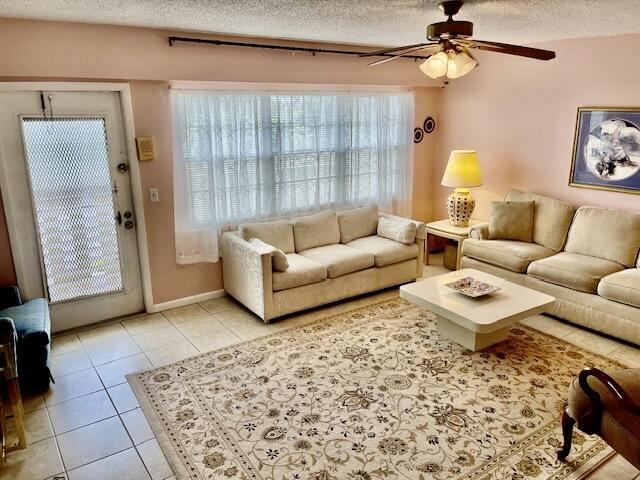 577 Mansfield N N Unit 577, Boca Raton, FL 33434 - living area with ceiling fan, a textured ceiling, healthy amount of natural light, and light tile patterned floors