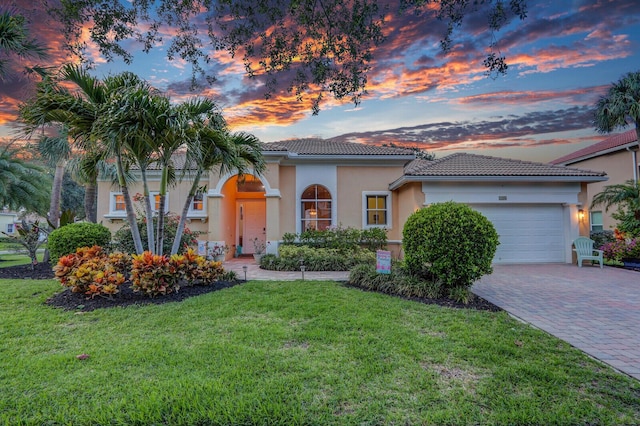 146 Magnolia Way, Tequesta, FL 33469 - mediterranean / spanish home with a tile roof, stucco siding, an attached garage, a yard, and decorative driveway