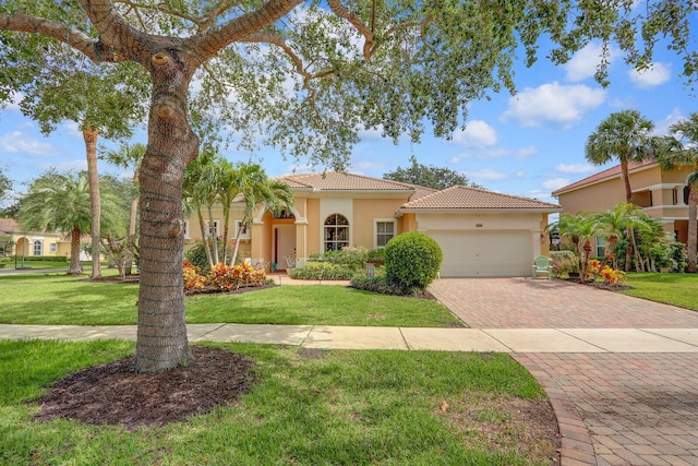 146 Magnolia Way, Tequesta, FL 33469 - mediterranean / spanish house with a garage, a tile roof, decorative driveway, stucco siding, and a front lawn
