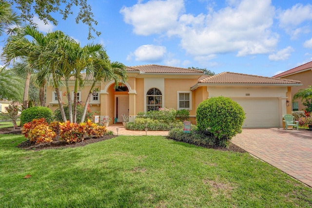 146 Magnolia Way, Tequesta, FL 33469 - mediterranean / spanish-style home featuring a garage, decorative driveway, a front yard, a tile roof, and stucco siding