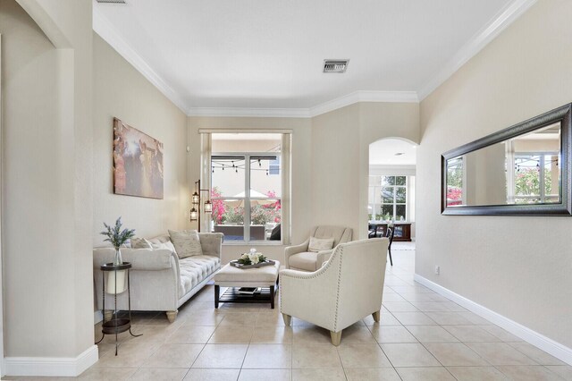 146 Magnolia Way, Tequesta, FL 33469 - living room featuring arched walkways, ornamental molding, light tile patterned floors, and baseboards