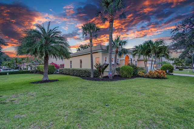 146 Magnolia Way, Tequesta, FL 33469 - property exterior at dusk featuring stucco siding and a lawn