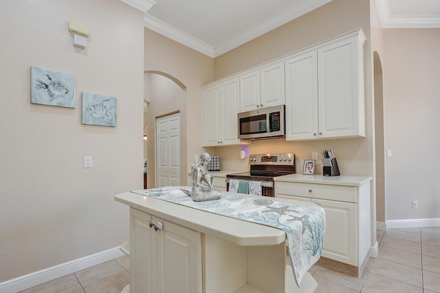 146 Magnolia Way, Tequesta, FL 33469 - kitchen featuring appliances with stainless steel finishes, arched walkways, light countertops, crown molding, and light tile patterned flooring