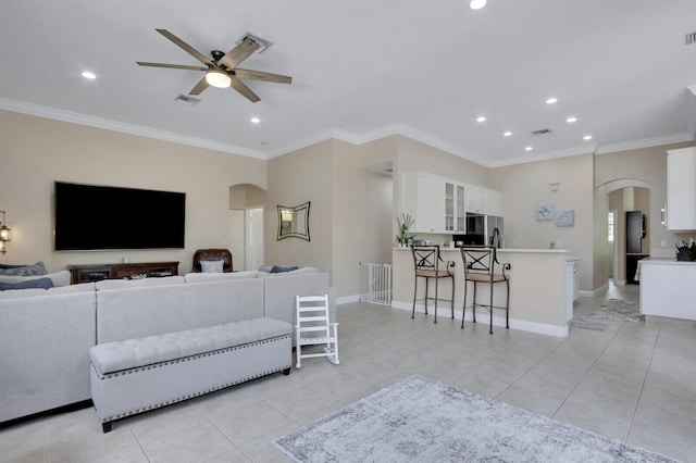 146 Magnolia Way, Tequesta, FL 33469 - living area featuring arched walkways, ceiling fan, recessed lighting, light tile patterned floors, and crown molding