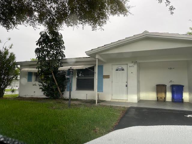4491 NW 1st Ter, Deerfield Beach, FL 33064 - view of front of house with driveway, a front yard, and stucco siding