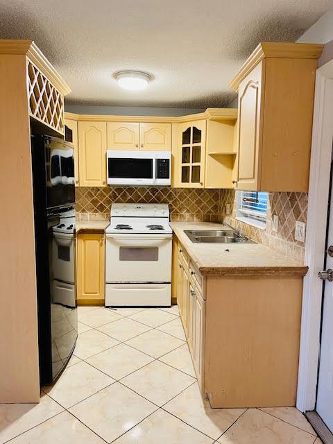 4491 NW 1st Ter, Deerfield Beach, FL 33064 - kitchen featuring white appliances, a sink, light countertops, backsplash, and a textured ceiling