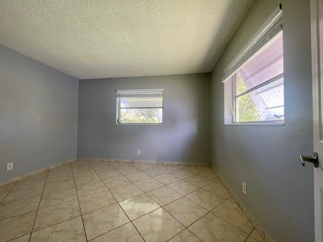 4491 NW 1st Ter, Deerfield Beach, FL 33064 - empty room with plenty of natural light, a textured ceiling, and baseboards