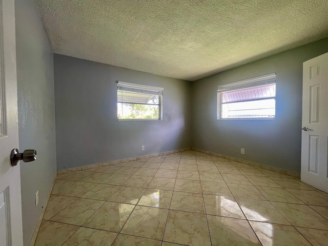 4491 NW 1st Ter, Deerfield Beach, FL 33064 - unfurnished room featuring plenty of natural light and a textured ceiling