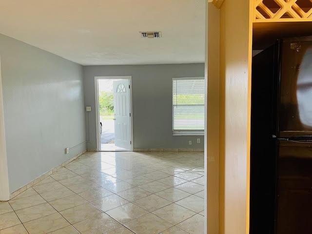 4491 NW 1st Ter, Deerfield Beach, FL 33064 - unfurnished room featuring plenty of natural light, light tile patterned flooring, and baseboards