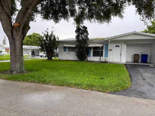 4491 NW 1st Ter, Deerfield Beach, FL 33064 - ranch-style house featuring a front yard, driveway, stucco siding, and an attached carport