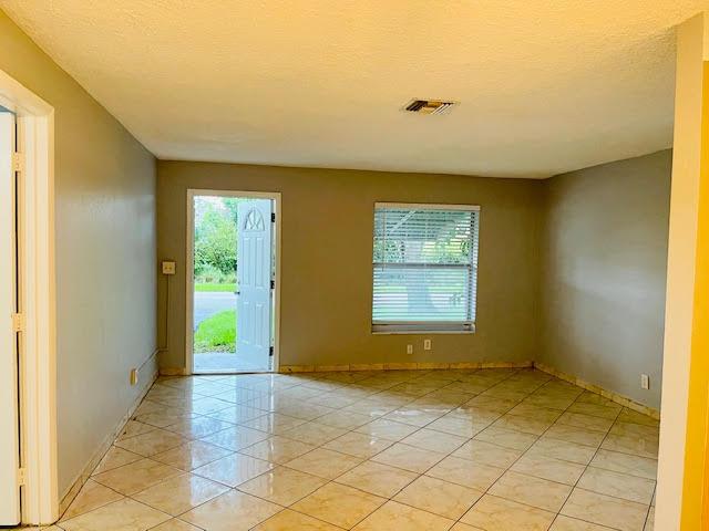 4491 NW 1st Ter, Deerfield Beach, FL 33064 - unfurnished room featuring baseboards and a textured ceiling