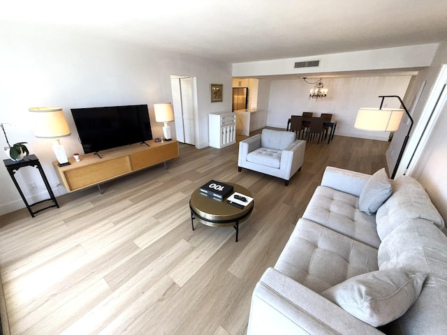 2860 S Ocean Blvd Unit 415, Palm Beach, FL 33480 - living room featuring a chandelier, light wood-type flooring, and baseboards