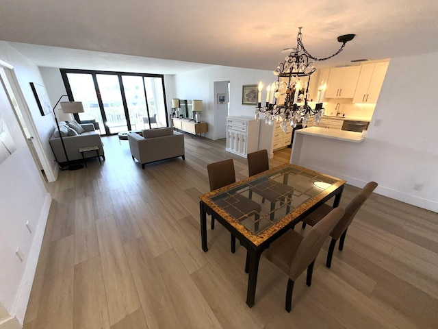 2860 S Ocean Blvd Unit 415, Palm Beach, FL 33480 - dining room with light wood-style flooring, a chandelier, and baseboards