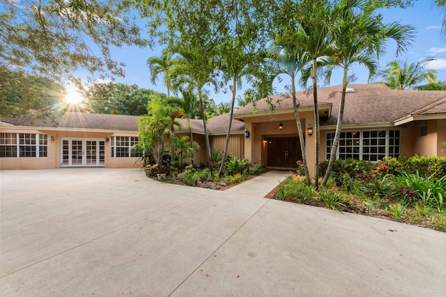 6935 Pioneer Rd, West Palm Beach, FL 33413 - view of front facade featuring french doors, driveway, stucco siding, and an attached garage