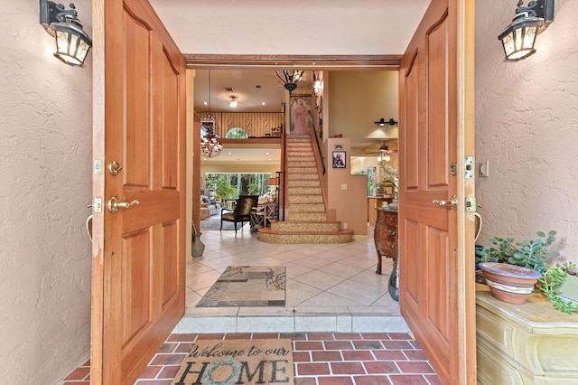 6935 Pioneer Rd, West Palm Beach, FL 33413 - entryway featuring a textured wall, stairway, and tile patterned floors