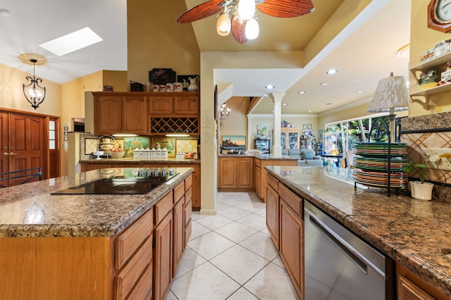 6935 Pioneer Rd, West Palm Beach, FL 33413 - kitchen with stainless steel dishwasher, black electric stovetop, a skylight, backsplash, and dark stone counters