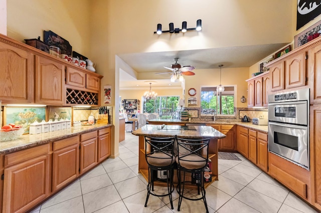 6935 Pioneer Rd, West Palm Beach, FL 33413 - kitchen featuring double oven, tasteful backsplash, light tile patterned floors, and light stone countertops