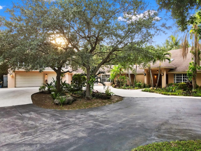 6935 Pioneer Rd, West Palm Beach, FL 33413 - view of front of property featuring curved driveway, a garage, and stucco siding