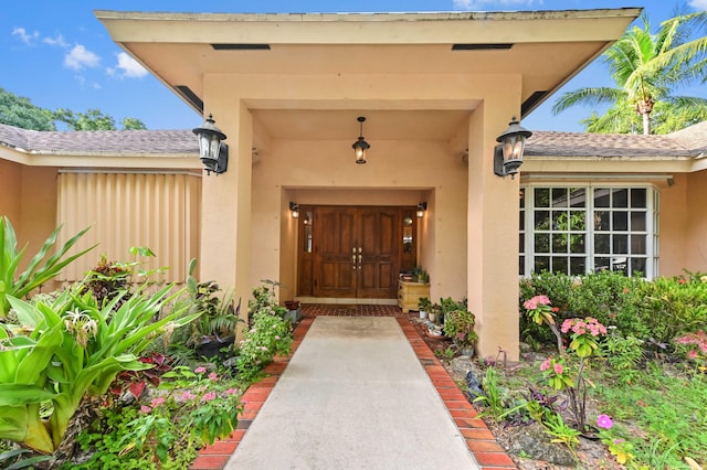 6935 Pioneer Rd, West Palm Beach, FL 33413 - view of exterior entry with stucco siding and roof with shingles