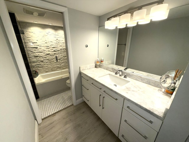 2425 Presidential Way Unit 1804, West Palm Beach, FL 33401 - bathroom with wood finished floors, toilet, vanity, bathtub / shower combination, and baseboards