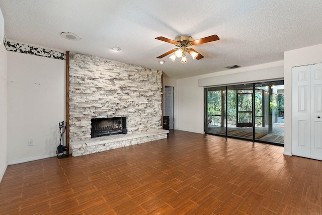 4904 River Pl, Fort Pierce, FL 34982 - unfurnished living room featuring a ceiling fan, a textured ceiling, a stone fireplace, baseboards, and wood finished floors