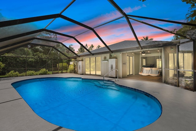 4904 River Pl, Fort Pierce, FL 34982 - pool at dusk with an outdoor pool, a patio area, a ceiling fan, and a lanai