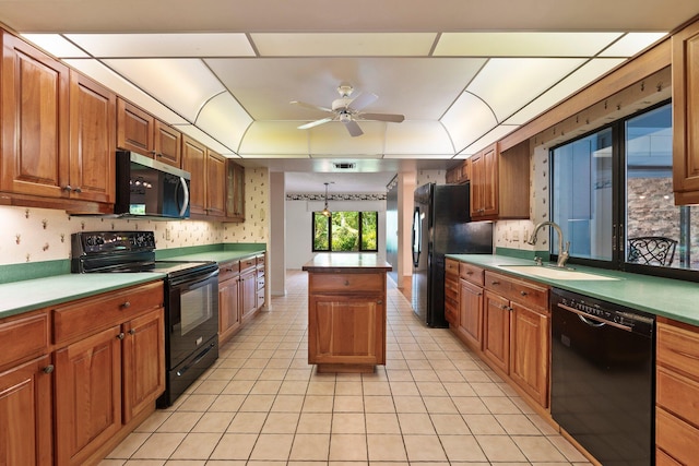4904 River Pl, Fort Pierce, FL 34982 - kitchen with black appliances, a sink, a ceiling fan, light tile patterned floors, and brown cabinets