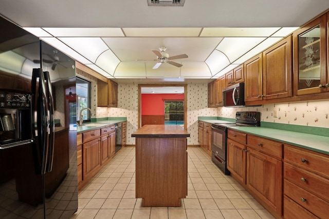 4904 River Pl, Fort Pierce, FL 34982 - kitchen with black appliances, ceiling fan, wallpapered walls, a sink, and a kitchen island