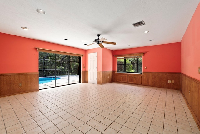 4904 River Pl, Fort Pierce, FL 34982 - empty room with wainscoting, wood walls, a ceiling fan, recessed lighting, and light tile patterned flooring
