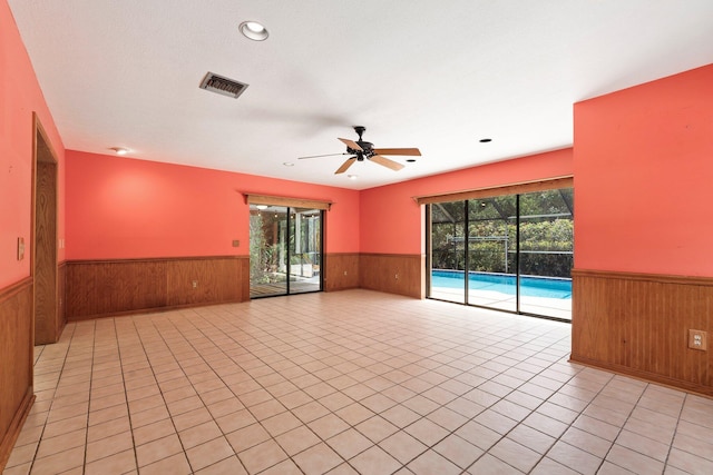 4904 River Pl, Fort Pierce, FL 34982 - empty room with wainscoting, wooden walls, ceiling fan, light tile patterned floors, and recessed lighting
