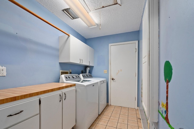 4904 River Pl, Fort Pierce, FL 34982 - laundry room featuring cabinet space, independent washer and dryer, light tile patterned floors, and a textured ceiling