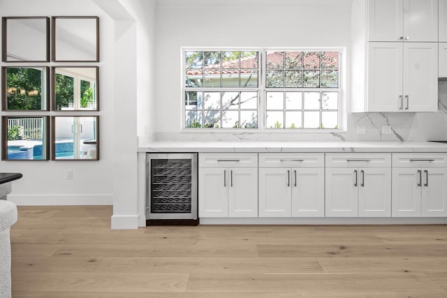 4689 Hammock Cir, Delray Beach, FL 33445 - bar featuring beverage cooler, plenty of natural light, baseboards, and light wood-style floors