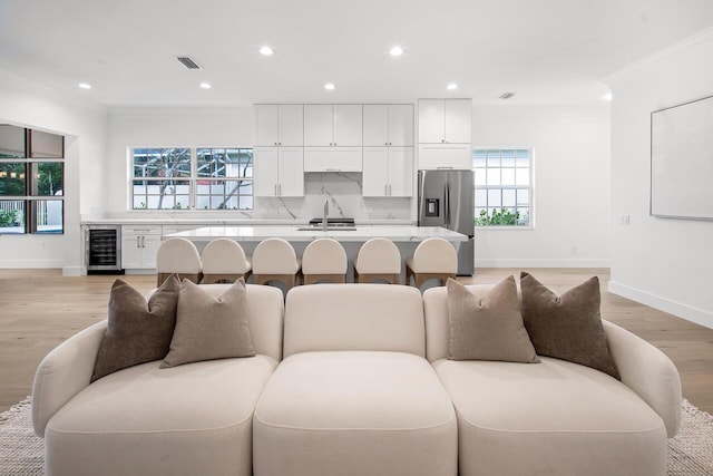 4689 Hammock Cir, Delray Beach, FL 33445 - living area with beverage cooler, baseboards, recessed lighting, light wood-type flooring, and crown molding
