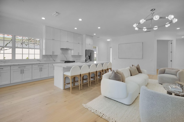4689 Hammock Cir, Delray Beach, FL 33445 - living area featuring light wood-type flooring, recessed lighting, a chandelier, and crown molding