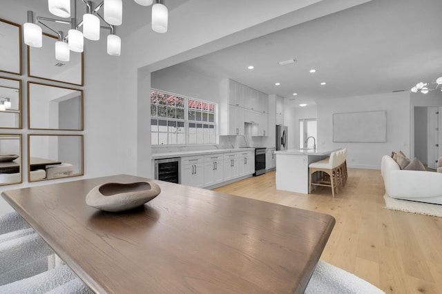 4689 Hammock Cir, Delray Beach, FL 33445 - dining room with a chandelier, wine cooler, light wood-style flooring, recessed lighting, and baseboards