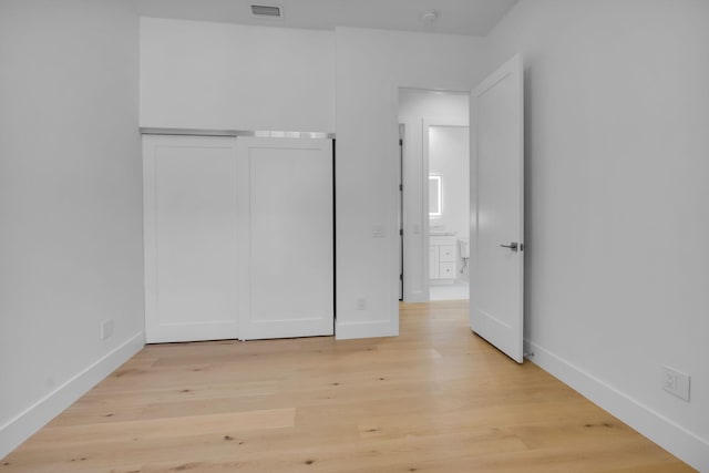 4689 Hammock Cir, Delray Beach, FL 33445 - unfurnished bedroom with light wood-style floors, a closet, and baseboards