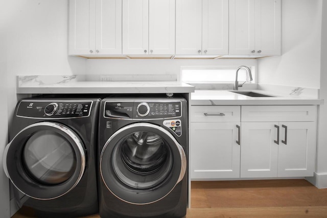 4689 Hammock Cir, Delray Beach, FL 33445 - laundry room featuring washer and dryer, wood finished floors, and cabinet space