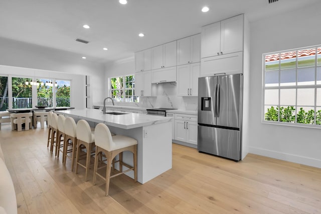 4689 Hammock Cir, Delray Beach, FL 33445 - kitchen with appliances with stainless steel finishes, a sink, light wood-style floors, an island with sink, and recessed lighting